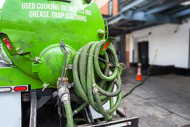 a grease trap being pumped by a sanitation technician in Marine City, MI